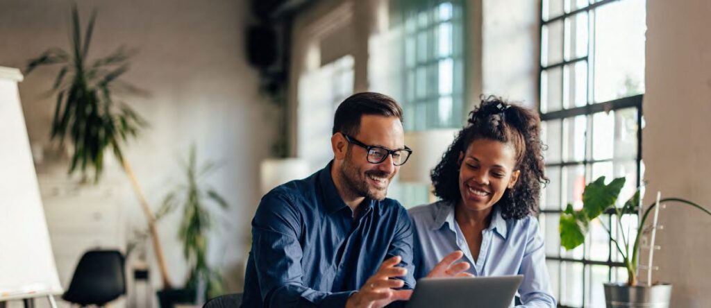 man with glasses and black woman working on a tablet