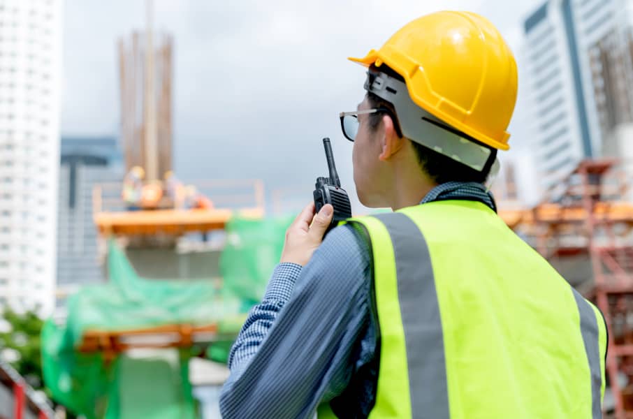 Worker speaking to the team via walkie-talkie at a construction site