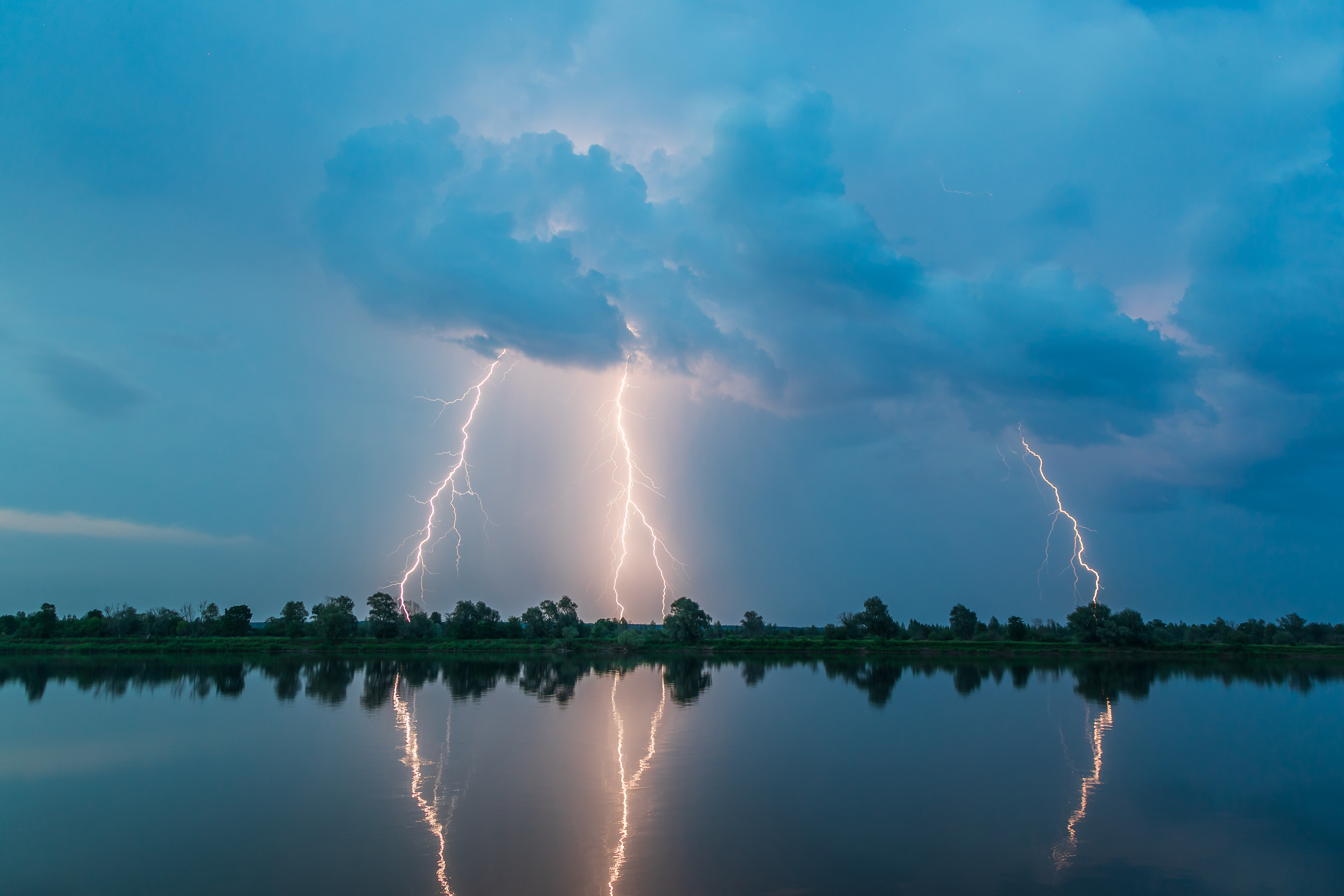 Bright night flash of lightning over the river